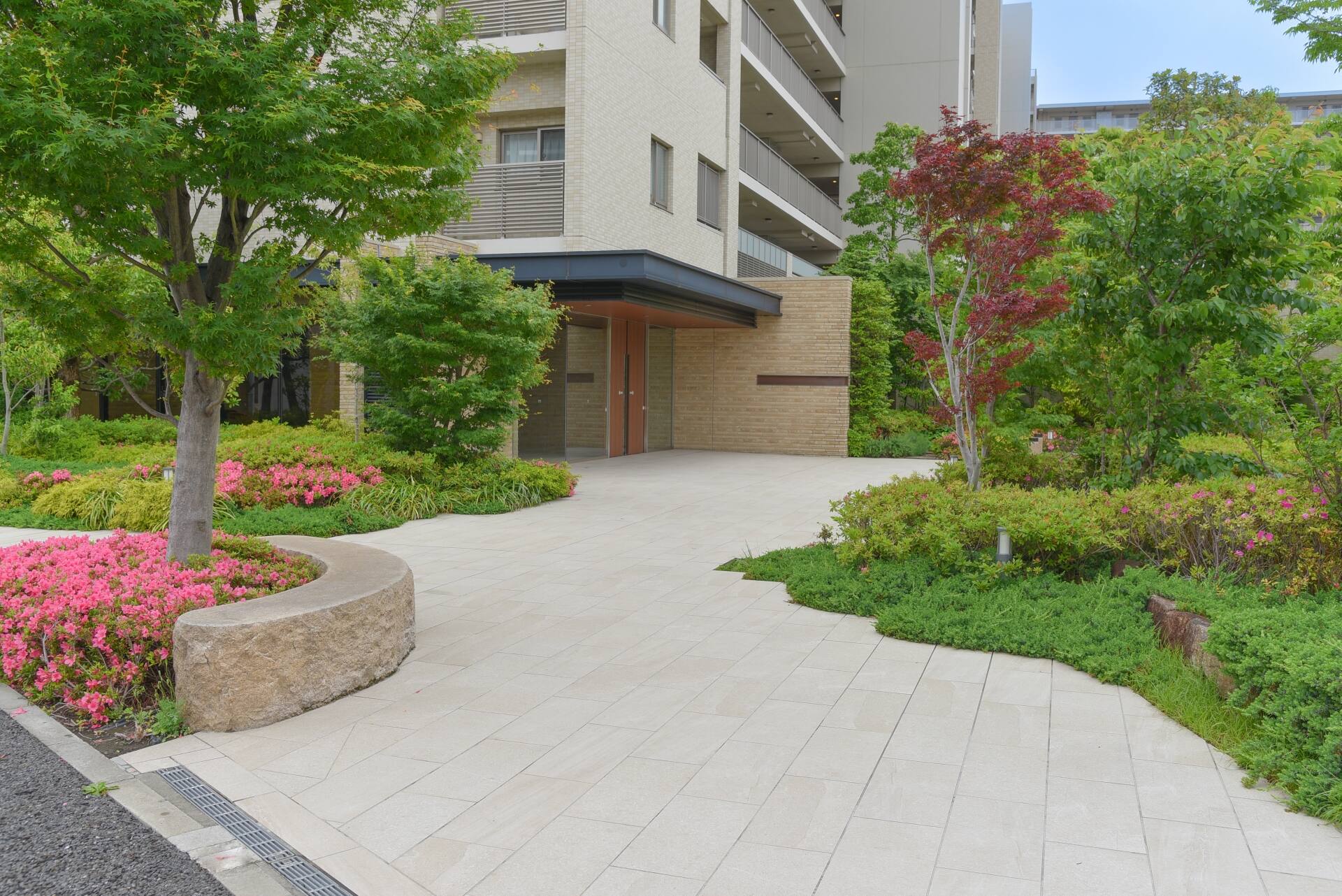 Modern exterior approach blending highly convenient paving with natural garden stones